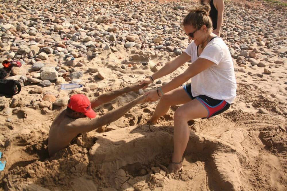 Helping a friend get out of a sandy situation on the beach in Morocco