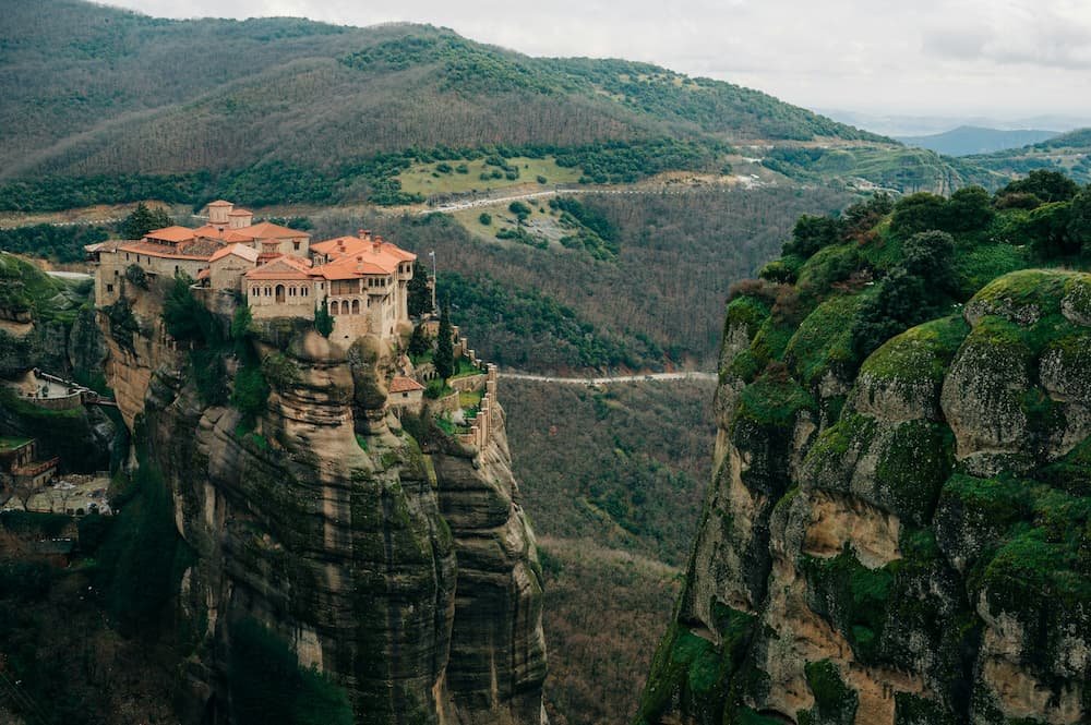 A monastry sits high above the valley