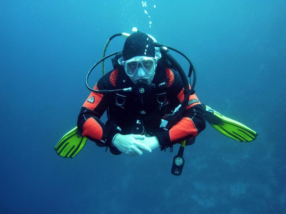 Scuba diver hovering-underwater with bright green fins