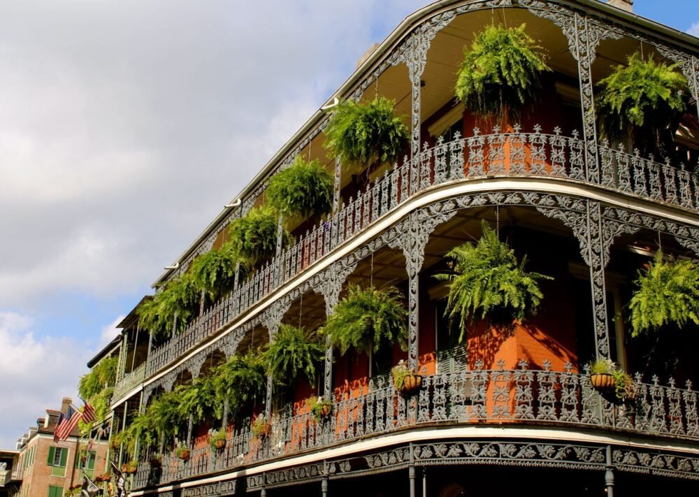 Ornate ironwork balconies with lush greenery in New Orleans